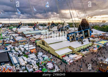 Flug durch den Münchner Himmel, vom Kettenflieger Bayern Tower bietet sich ein toller Blick auf das Oktoberfest, München, Oktober 2024 Deutschland, München, Oktober 2024, Wiesnbesucher genießen den Flug durch den Münchner Himmel, in 90 Meter Höhe haben sie einen wunderbaren Blick über das Oktoberfest, Kettenflieger Bayern Tower, 90 Meter hohes Kettenkarussell, Theresienwiese, Fahrgeschäft gehört Schausteller Egon Kaiser, Mittwochabend, Himmel bewölkt mit einzelnen Lichtblicken, Wiesnwetter, bayerisch, Volksfest, Herbst, Bayern, *** Flug durch den Münchner Himmel, vom Kettenflieger Bayern Stockfoto