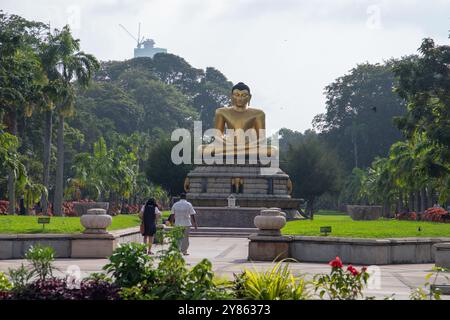 Colombo, Sri Lanka - Dezember 2021: Sri Lanka Buddha-Statue. Die Buddha-Statue befindet sich im Viharamahadevi-Park. Die Leute laufen durch den Park Stockfoto