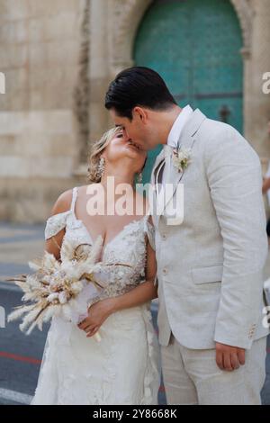 Frisch vermählte küssen sich nach der Zeremonie auf der Straße, Alicante, Spanien Stockfoto