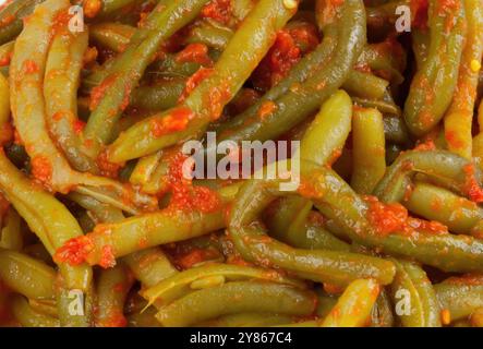 Gedämpfte grüne Bohnen, bedeckt mit einer köstlichen Tomatensauce, machen eine gesunde und leckere Mahlzeit Stockfoto