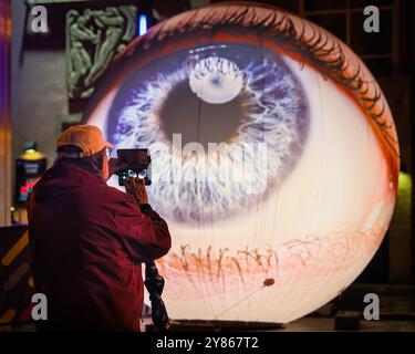 Essen, NRW, Deutschland. Oktober 2024. Besucher interagieren mit der Installation „Oculus“ der Künstler H:E:M (Italien) außerhalb des Grillo-Theaters. Zwei riesige Kugeln leuchten in Form von zwei Augen, die in den Himmel blicken. Eröffnungsabend des jährlichen Essen Light Festivals mit 16 großformatigen Lichtinstallationen in der ganzen Stadt. Das Festival ist frei zu sehen und findet jeden Abend von Sonnenuntergang bis 23 Uhr vom 2. Bis 13. Oktober 2024 statt. Quelle: Imageplotter/Alamy Live News Stockfoto