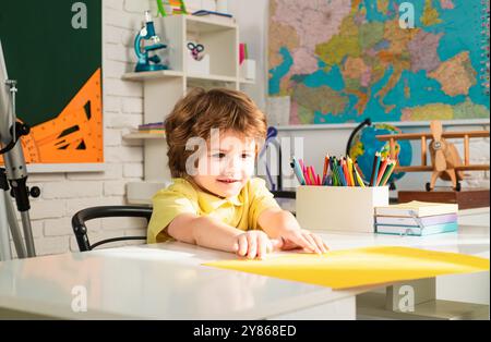 Kinder machen sich bereit für die Schule. Kind in der Nähe der Tafel in der Schule Klassenzimmer. Bildungsprozess. Stockfoto
