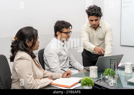 IT-Team Office-Meeting in moderner Büroumgebung mit indischen Millennial-Kollegen und verschiedenen Kollegen, die sich mit der Zusammenarbeit beschäftigen, Stockfoto