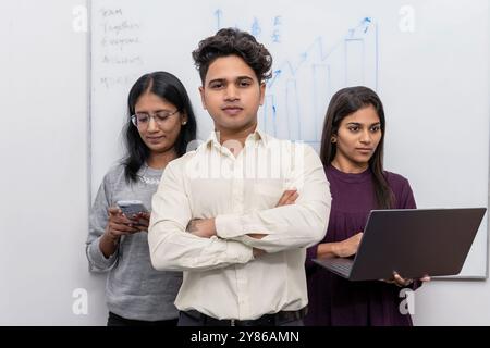 Ein professionelles dreiköpfiges Business-Team mit einem selbstbewussten Teammanager, der an vorderster Front mit zwei unterstützenden weiblichen Mitarbeitern in der BA steht Stockfoto