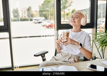 Eine junge kahlköpfige Frau genießt einen Drink und genießt Ruhe in einer schicken Umgebung. Stockfoto