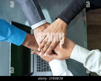 Eine Nahaufnahme der vielfältigen, multiethnischen Mitarbeiter, die ihre Hände in einen Haufen stapeln, um gegenseitige Unterstützung und Engagement sowie das Wesen der Einheit zu demonstrieren Stockfoto