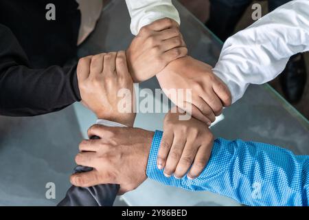 Eine vielfältige Gruppe von Geschäftsleuten, die in einer Umgebung von oben zusammenarbeiten. Die Hände werden in verschiedenen Gesten gezeigt, die Teamarbeit symbolisieren, Vertrauen. Stockfoto