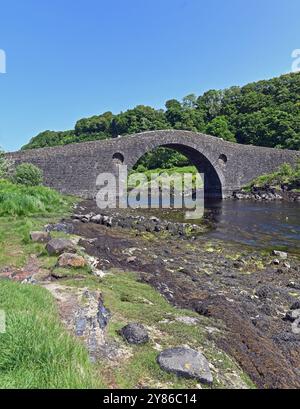 Die Clachan Bridge (auch bekannt als die Brücke über den Atlantik) ist eine einfache, einbogige, buckelige Mauerbrücke, die den Clachan Sound 13 überspannt Stockfoto