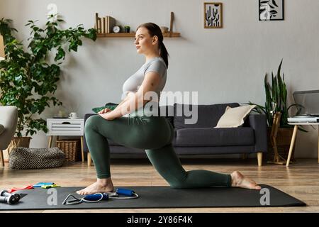 Eine engagierte junge Frau nimmt zu Hause eine Longenübung in stilvoller aktiver Kleidung an. Stockfoto