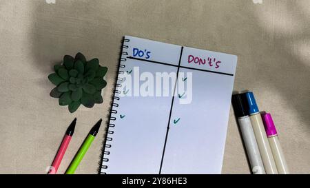 Das Konzept von Do's oder Don'TS schreibt auf einem Buch, das auf einem Holztisch isoliert ist. Stockfoto