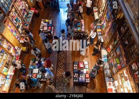 Porto, Portugal - 12. September 2024 : Besucher erkunden einen gut sortierten Buchladen mit vielfältigen Büchern und gemütlichem Ambiente. Stockfoto