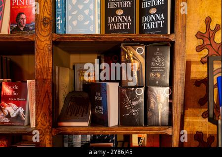 Porto, Portugal - 12. September 2024: Besucher erkunden einen charmanten Buchladen mit einer verzierten roten Treppe und Holzregalen Stockfoto