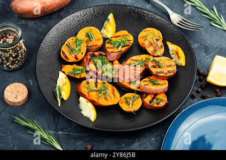 Gebratene Süßkartoffeln auf dem Grill mit Kräutern. Veganes Lebensmittelkonzept. Stockfoto