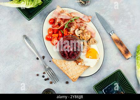 Gebratener Speck und Eier, Toast und Bohnen und Gemüse. Amerikanisches Frühstück. Stockfoto