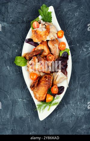 Köstliche Stücke gebackenes gebackenes Hühnchen mit Grün auf einem Teller. Stockfoto