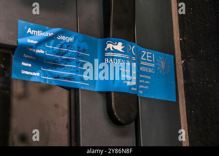03. Oktober 2024, Baden-Württemberg, Göppingen: Am Eingang einer Bar in Göppingen wird ein Polizeisiegel befestigt. Schüsse in der Bar im Stadtzentrum töteten letzte Nacht einen Mann, zwei weitere Menschen wurden verletzt und ins Krankenhaus gebracht. Die Polizei sucht den mutmaßlichen Täter. Foto: Christian Wiediger/onw-images/dpa Stockfoto