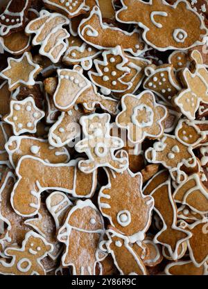 Eine große Anzahl verschiedener Lebkuchenformen mit traditionellen Weihnachtsmotiven, die mit weißem Zucker verziert sind. Weihnachtliche Lebkuchenflachlage Stockfoto