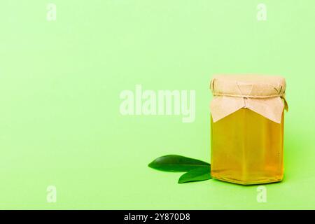 Honig im Glas mit Blättern und Honigtaube auf farbigem Hintergrund Draufsicht mit Text kopieren. Stockfoto