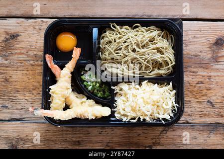 Chinesische Tempura-belegte King Garnelen-bento-Box, serviert mit Nudeln, eingelegtem Gemüse und einem rohen Eierdip Stockfoto