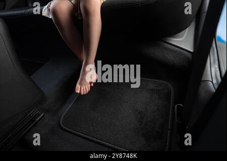 Kind barfuß in schwarzem Autoteppich Hintergrund Nahansicht Stockfoto