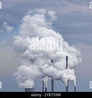 Mehrere Schornsteine eines Kraftwerks werfen große Rauchwolken in die Luft Stockfoto