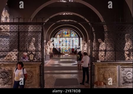 Siena, Italien - August 9,2023: Blick in das Museum der Kathedrale von Siena mit einem atemberaubenden Buntglasfenster und umliegenden Statuen. Stockfoto