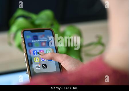 Berlin, Deutschland. Juli 2024. Eine Frau öffnet auf ihrem Smartphone einen Ordner mit Apps aus verschiedenen sozialen Medien. Quelle: Niklas Graeber/dpa/Alamy Live News Stockfoto