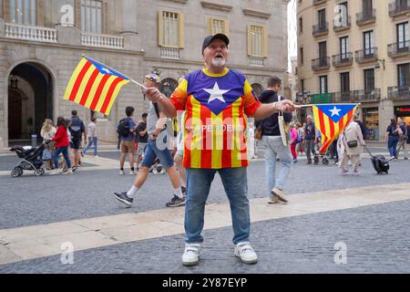 Barcelona, Spanien. Oktober 2024. Barcelona, Spanien, 2. Oktober 2024: Ein Mann in Barcelona, Spanien, steht auf einem öffentlichen Platz mit einer katalanischen Flagge und trägt ein T-Shirt mit der Aufschrift Independencia, symbolisiert seine Unterstützung für die katalanische Unabhängigkeitsbewegung inmitten einer lockeren Menschenmenge (generisches Stockfoto und repräsentatives Bild) (Daniela Porcelli/SPP) Credit: SPP Sport Press Photo. /Alamy Live News Stockfoto