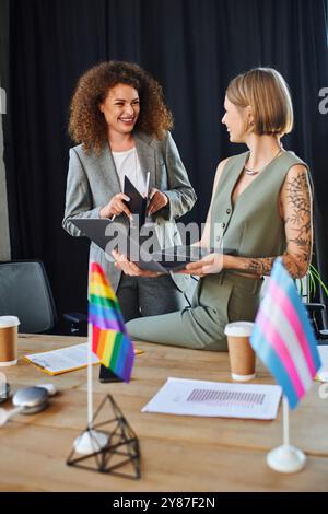 Zwei Kollegen teilen einen freudigen Moment, während sie Vielfalt und Integration am Arbeitsplatz feiern. Stockfoto