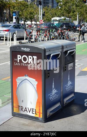 Hafen von San Francisco Big Belly Solar Compactor Mülltonnen mit Fahrrädern dahinter. Stockfoto