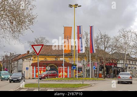 Pozarevac, Serbien - 14. März 2024: Drei vertikale Flaggen an der Kreuzung des Kreisverkehrs am Frühlingstag des Stadtzentrums. Stockfoto