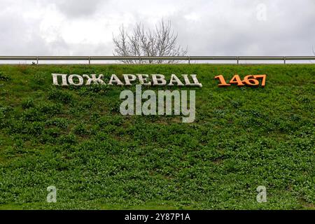 Pozarevac, Serbien - 14. März 2024: 3D-Zeichen kyrillische Schriftzeichen Pozarevac seit 1467 am Stadteingang Grass Embankment Frühlingstag. Stockfoto