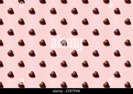 Herzförmige Schokoladenstücke auf weichem rosa Hintergrund, Valentinstag Hintergrund Stockfoto