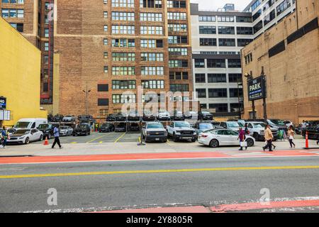 Außenparkplatz an der 34th Street im Stadtzentrum von Manhattan mit mehrstöckigem Autoverstellraum und Fußgängern. New York. USA. Stockfoto