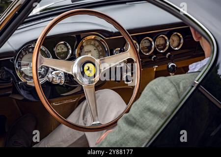 Mann sitzend und zeigt Innenraumverkleidung von 1962 Ferrari 250 GT Berlinetta SWB. Concours of Elegance 2024, Hampton Court Palace, London, Großbritannien Stockfoto