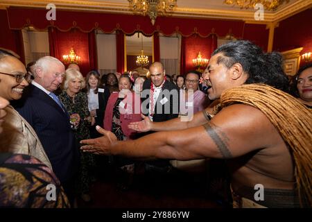 König Karl III. Reagiert, als der ehemalige samoanische Rugbyspieler Freddie Tuilagi bei einem Empfang im St. James's Palace tanzt, der die Commonwealth Diaspora feiert. Stockfoto