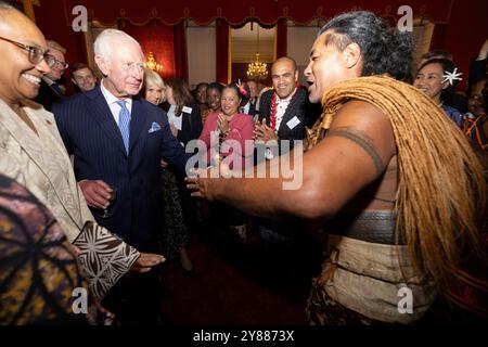 König Karl III. Reagiert, als der ehemalige samoanische Rugbyspieler Freddie Tuilagi bei einem Empfang im St. James's Palace tanzt, der die Commonwealth Diaspora feiert. Stockfoto