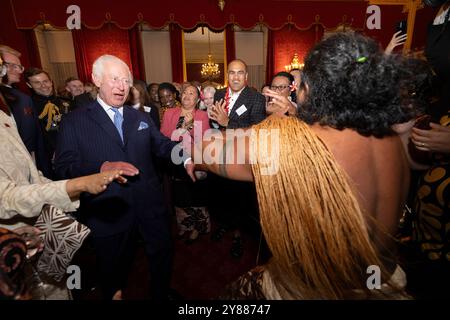 König Karl III. Reagiert, als der ehemalige samoanische Rugbyspieler Freddie Tuilagi bei einem Empfang im St. James's Palace tanzt, der die Commonwealth Diaspora feiert. Stockfoto