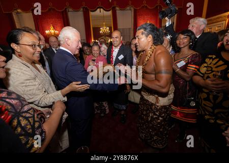 König Karl III. Reagiert, als der ehemalige samoanische Rugbyspieler Freddie Tuilagi bei einem Empfang im St. James's Palace tanzt, der die Commonwealth Diaspora feiert. Stockfoto