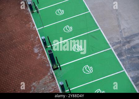 Leere Parkplätze mit Beschilderung zum Aufladen von Elektroautos. Blick von oben. Stockfoto