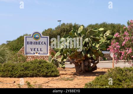Großes Namensschild aus Stein für den Badeort Binibeca Vells auf der spanischen Insel Menorca. Stockfoto