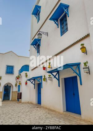 Traditionelles tunesisches Haus mit blauen Fenstern in einer winzigen Gasse Stockfoto