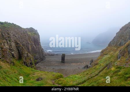 Nebelige Meereslandschaft am Strand Trá-na-mBó, Bunmahon, Irland – ruhige Strandszene mit Rocky Shores und sanften Wellen Stockfoto