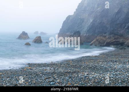 Wilder und geheimnisvoller Strand Trá-na-mBó, Bunmahon, Irland – die felsige Küste in Fog and Mist sorgt für eine unüberirdische Atmosphäre Stockfoto