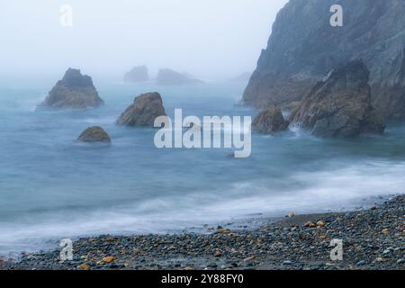 Wilder und geheimnisvoller Strand Trá-na-mBó, Bunmahon, Irland – die felsige Küste in Fog and Mist sorgt für eine unüberirdische Atmosphäre Stockfoto