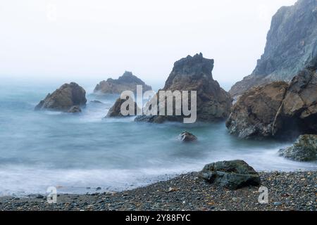 Wilder und geheimnisvoller Strand Trá-na-mBó, Bunmahon, Irland – die felsige Küste in Fog and Mist sorgt für eine unüberirdische Atmosphäre Stockfoto