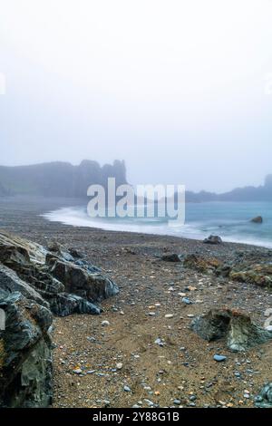 Wilder und geheimnisvoller Strand Trá-na-mBó, Bunmahon, Irland – die felsige Küste in Fog and Mist sorgt für eine unüberirdische Atmosphäre Stockfoto