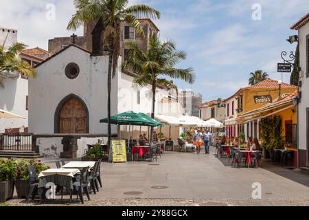 Die Gäste genießen die gemütlichen Terrassen neben der mittelalterlichen Kapelle Corpo Santo im historischen Viertel Zona Velha in Funchal. Stockfoto