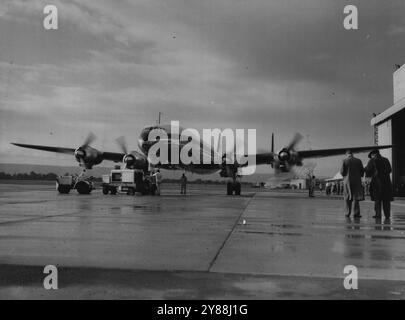 Während die Bodencrew in letzter Minute Kontrollen durchführt, fährt der Pilot dieses Qantas Super Constellation Flugzeugs auf die Landebahn zu, um nach Singapur auf dem Weg nach London zu starten. Gestern fuhr das Flugzeug, die Southern Moon, über den Flughafen Perth auf dem ersten Flug des neuen Dienstes von Sydney nach London über Perth. An Bord des Flugzeugs waren 27 Passagiere, von denen drei in Perth antraten, und eine Mannschaft von 11 Personen unter der Leitung von Captain D. F. MacMaster. Auf dem Bild sind Captain MacMatter (rechts) mit Miss Put Letcher, einer Gastgeberin, und Captain B. Henderson. September 1955. Stockfoto