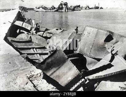 Zerstörte Achsenschiffe auf BengasiBlasted-Schiffen, einige mit Schildern, die aus den Rümpfen gerissen wurden, überschwemmten die Uferpromenade von Bengasi, nachdem britische und amerikanische Luftstreitkräfte während der Offensive in der afrikanischen Wüste Marschall Rommels lebenswichtigen Versorgungshafen zerstört hatten. Februar 1943. (Foto: Interphoto News Pictures, Inc.) Stockfoto